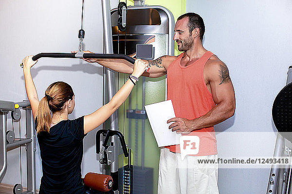 Frau im Fitnessstudio trainiert mit ihrem Personal Trainer. Antalya Türkei