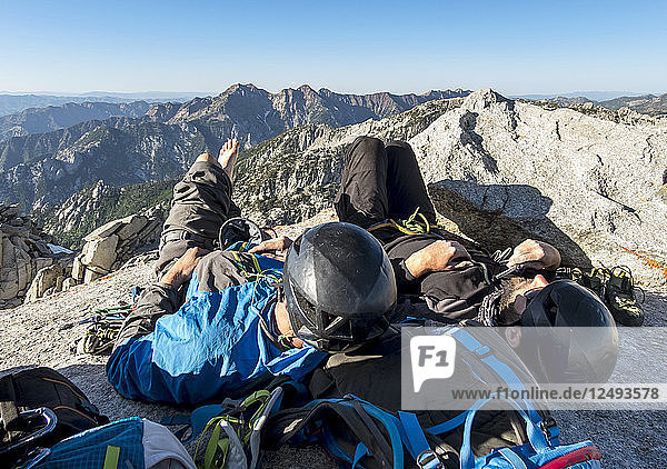 Zwei Männer ruhen sich auf dem Gipfel des Lone Peak nach einem langen  anstrengenden Aufstieg auf der Kletterroute Open Book in den Wasatch Mountains von Utah aus.