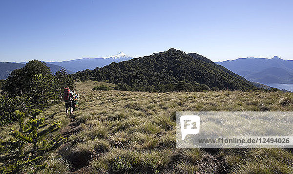 Wandererpaar auf Alpenkamm mit Vulkan im Hintergrund