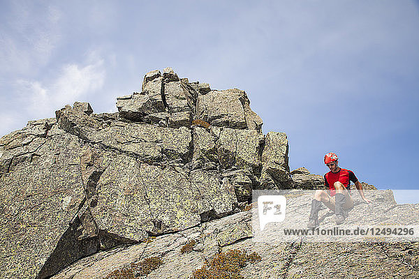 Ein Bergsteiger klettert einen felsigen Gipfel in British Columbia  Kanada  hinunter.
