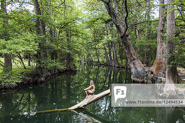 Eine junge Frau genießt ein ruhiges Schwimmloch  das Blue Hole  in der Nähe von Wimberley  Texas.