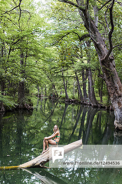 Eine junge Frau genießt ein ruhiges Schwimmloch  das Blue Hole  in der Nähe von Wimberley  Texas.