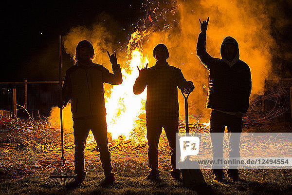 Eine Gruppe von Freunden steht vor einem großen Lagerfeuer während einer letzten Nacht in Revelstoke  Kanada
