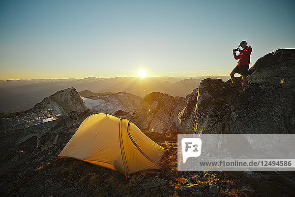 A hiker takes a picture of his tent while camping on Saxifrage Peak  Pemberton  BC  Canada.