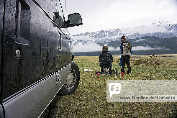 Friends Camping With Van In Meadow In Canada