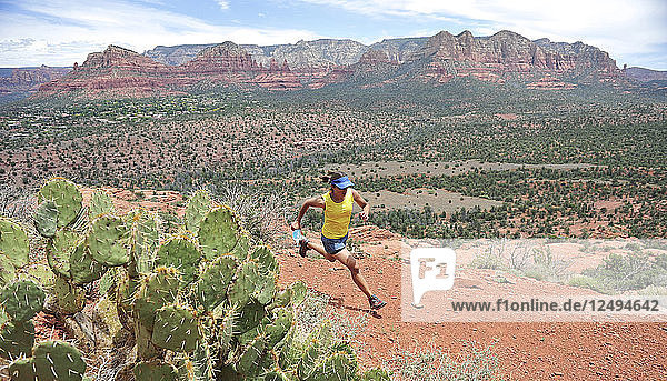 Woman runs the Cathedral Rock Trail in Sedona  Arizona May 2011. The trail over slick rock sandstone leads to a popular group of spires above Sedona. (Model Release: Agnes Hage)