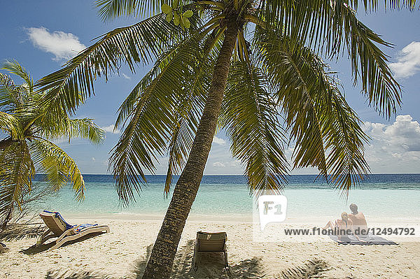 Ein Paar entspannt sich am Strand eines Inselresorts im Süd-Male-Atoll  Malediven.