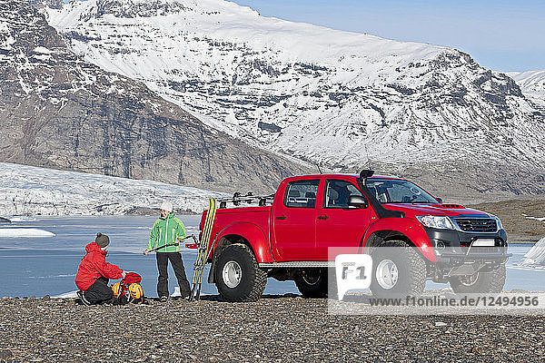 Pärchen macht sich bereit für eine Skitour vor einem maßgeschneiderten SUV / isländischen Superjeep