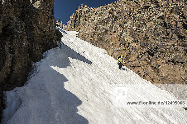 A Woman Descending A Snow Slope While Hiking On Blaine Peak Below Mount Sneffels