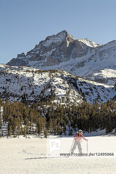 A Young Girl Ski Skating Back Home On A Frozen Lake In Rock Creek Canyon  California  Usa