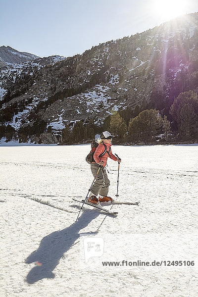 Young Girl Ski Skating On A Frozen Lake In Rock Creek Canyon  California  Usa