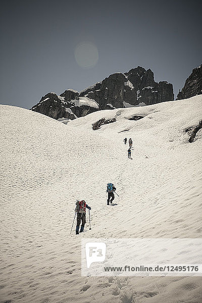 Sechs Bergsteiger durchqueren ein Schneefeld auf dem Weg zum Trio Peak in British Columbia  Kanada.