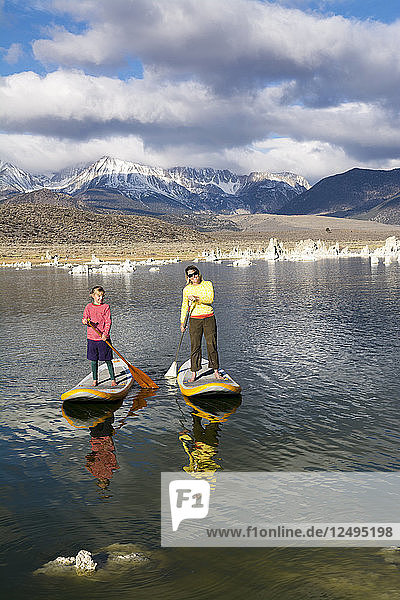 Woman And Her Daughter Paddleboarding On Mono Lake In California  Usa