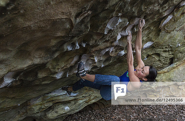 Sportliche Frau versucht sich an einer überhängenden Felswand in Rocktown  Georgia