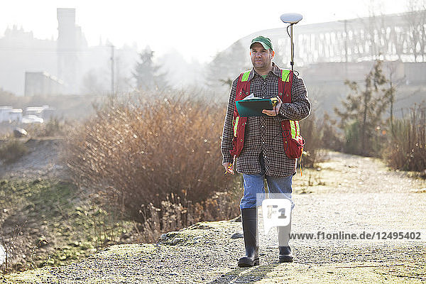A Field Technician collects data with a GPS unit in North Vancouver  B.C.