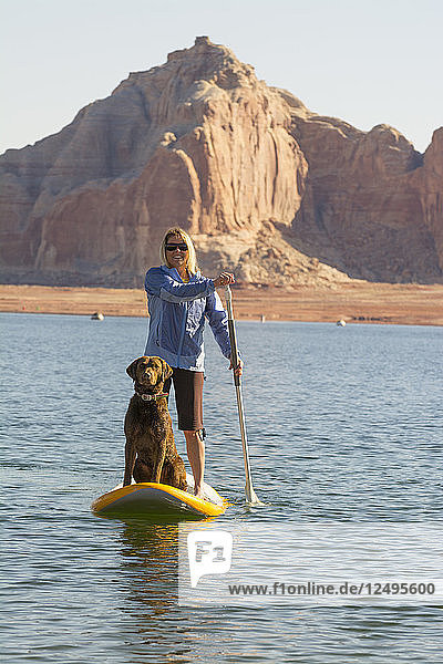 Eine Frau und ihr Hund paddeln auf dem Lake Powell  Wahweap Marina  Glen Caynon National Recreation Area  Page  Arizona.
