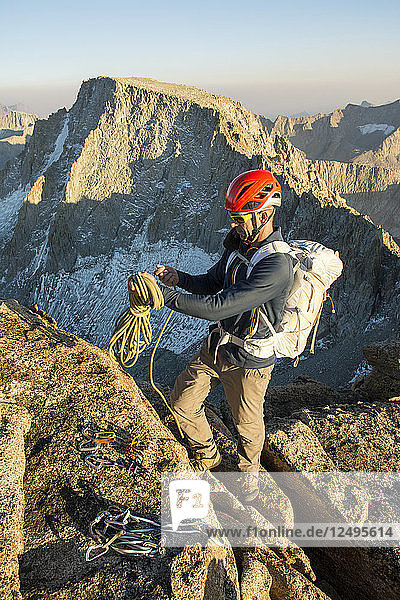 Ein Mann wickelt ein Seil auf dem Gipfel des Mount Mendel entlang der 8 5 Meilen langen Evolution Traverse  John Muir Wilderness  Kings Canyon National Park  Bishop  Kalifornien.