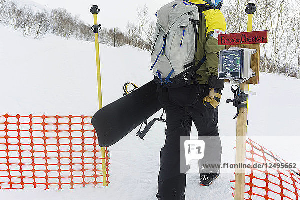 Snowboarder Entering The Backcountry Through A Gate At A Ski Resort In Niseko  Japan