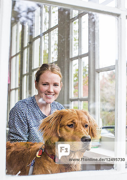 Eine junge Hundebesitzerin genießt die Zeit mit ihrem Hund in ihrem Haus.