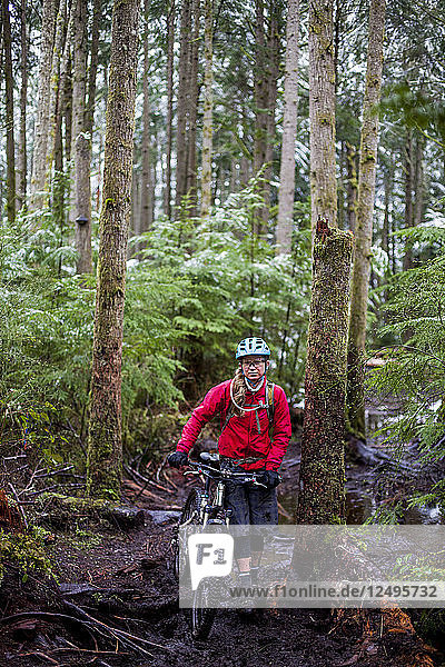 A female mountain biker on a rainy  snowy day in Issaquah  Washington.