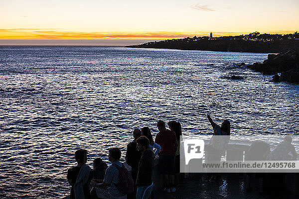 Menschen versammeln sich  um den Sonnenuntergang am Atlantischen Ozean zu beobachten  Lissabon  Portugal