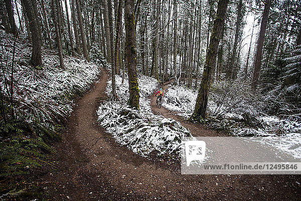 Eine Mountainbikerin an einem regnerischen  verschneiten Tag in Issaquah  Washington.