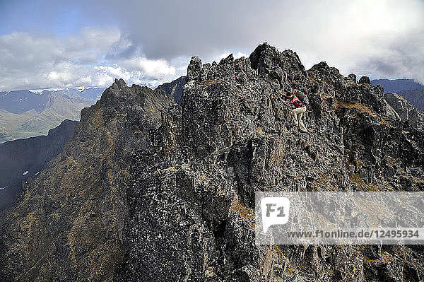 Eine Wanderin nähert sich dem Gipfel des Tikishla Peak (5230 m) im Snowhawk Valley in den Chugach Mountains nördlich von Anchorage  Alaska  im August 2011. Obwohl das Snowhawk Valley 5 von 12 Gipfeln über 5000 m in der Chugach Front Range beherbergt  wird es aufgrund des schwierigen Zugangs nur sehr wenig besucht. In der Sprache der Dena'iai bedeutet Tikishla Schwarzbär.
