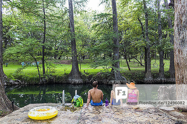 The Blue Hole in Wimberley Texas is a popular destination for tourists and locals on hot summer days. The clear cool water flows through cypress trees and offers a refuge from the Texas heat.