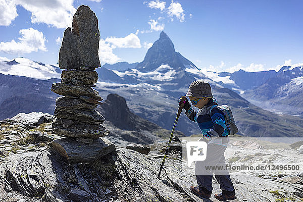 Young Child Walking Towards A Cairn With The Matterhorn In The Background