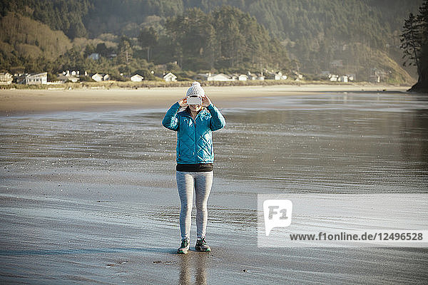 Eine junge Frau macht mit ihrem Smartphone ein Foto vom Neskowin Beach.