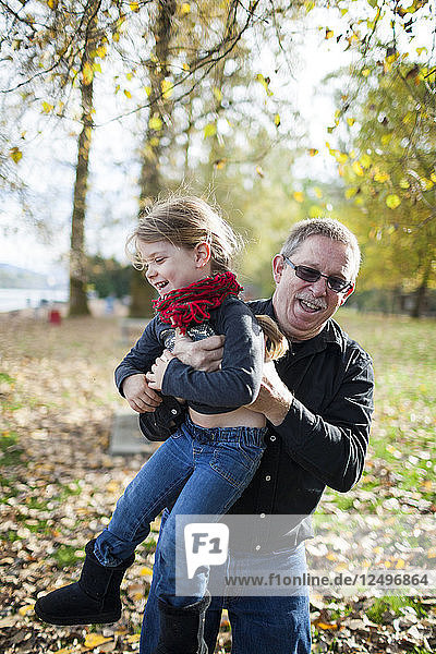 Grandfather Playing With His Granddaughter In The Park