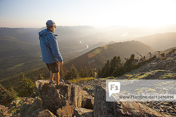 Ein Wanderer blickt vom Gipfel des Sauk Mountain in der North Cascade Mountain Range  Washington  auf das Skagit Valley und den Fluss hinunter.
