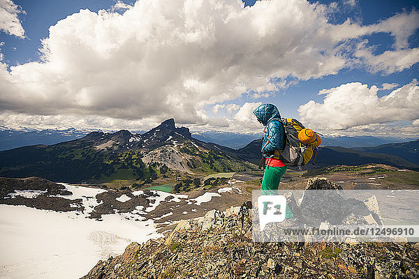 A young woman hiking on Panorama Ridge with Black Tusk Mountain in the background in Garibaldi Provincial Park  British Columbia  Canada.