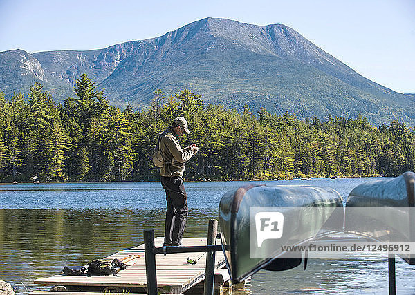 Fliegenfischer bei der Vorbereitung seiner Ausrüstung auf dem Steg am Kidney Pond im Baxter State Park  Maine