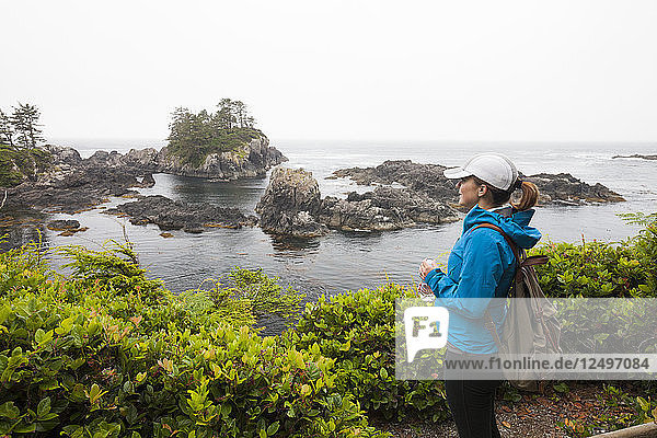 Eine junge  sportliche Frau hält an einem Aussichtspunkt entlang des Wild Pacific Trail  Vancouver Island  British Columbia.