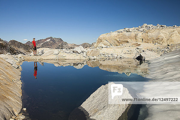 Reflexion eines Wanderers in einem von einem Gletscher gespeisten alpinen Tümpel in der Nähe von Whistler  British Columbia  Kanada.