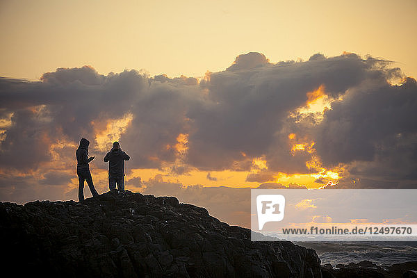 A young couple enjoys the sunset from Lincoln Beach  Oregon.