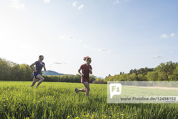 Two Women Running In A Grassy Field In New Hampshire