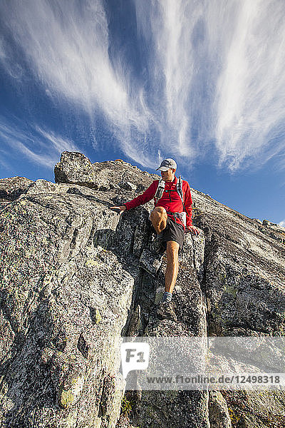 Ein Rucksacktourist klettert eine Felsstufe am Saxifrage Mountain in Pemberton  British Columbia  Kanada  hinunter.
