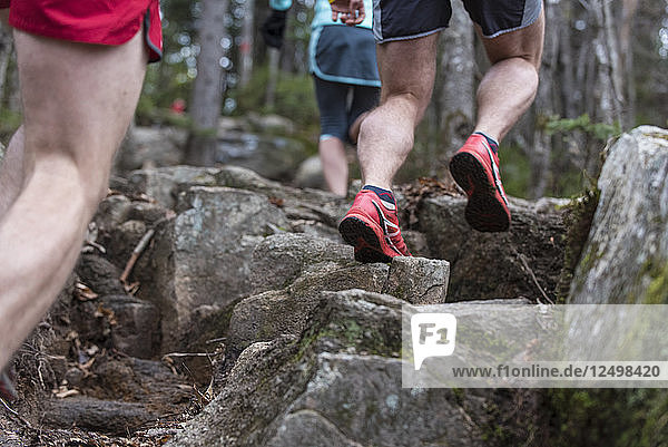 Trail runners on hard granite rocks adn ledges in the White Mountains of NH.