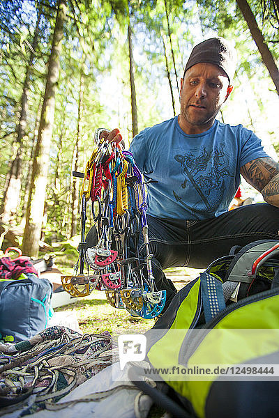 A climber holds up his trad gear rack.