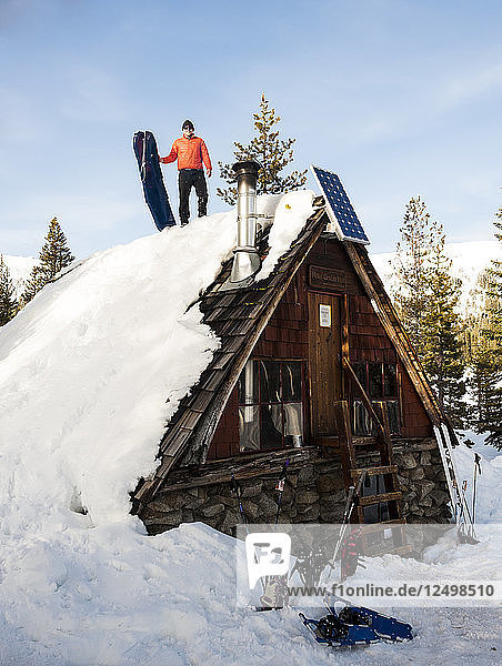 Mann bereitet sich auf eine weitere Schlittenfahrt vom Dach der Peter Grubb Skihütte vor  Sierra Nevada