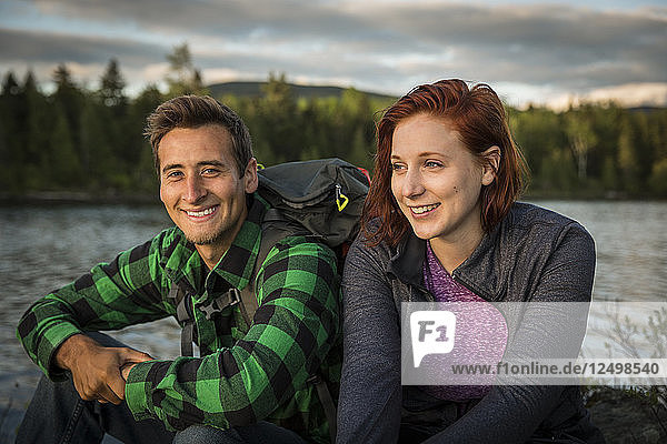Ein junges Paar neben Long Pond in Maine's North Woods in der Nähe von Greenville  Maine