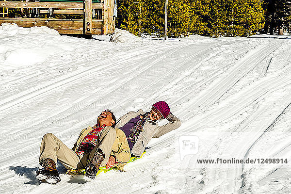 couple sledding in the snow