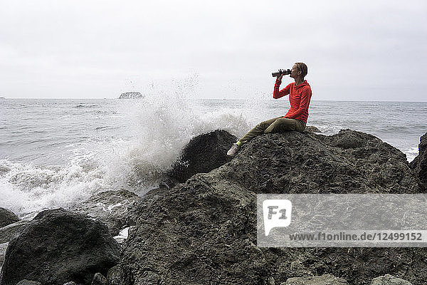 A Woman Drinking Coffee On The Coast Of Olympic National Park
