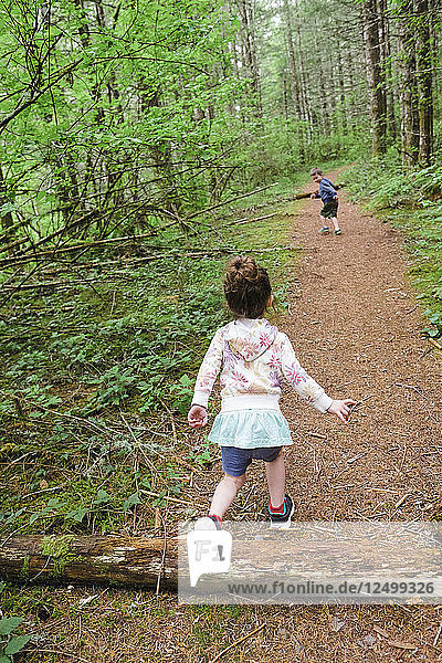 Brother And Sister Trail Running Through Oregon Forest