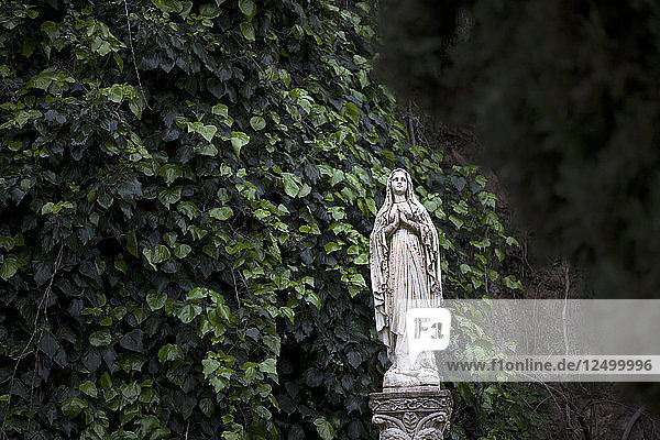 Eine Skulptur der Jungfrau Maria schmückt eine Gartenanlage in Zahara de la Sierra  Naturpark Sierra de Grazalema  Provinz Cádiz  Andalusien  Spanien