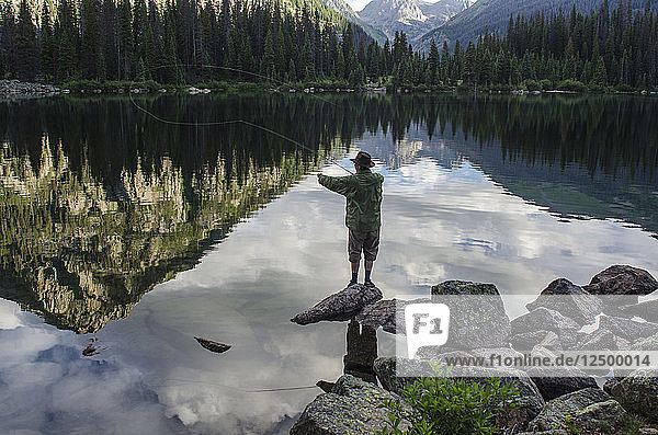 Photographer Jeremy Wade Shockley casts his fly line accross Emerald Lake  Weminuche Wilderness  Southwest Colorado.