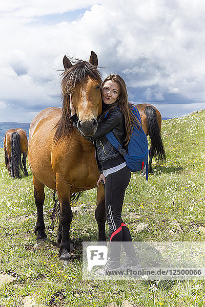 Frau umarmt Pferd am Berg Stolovi in der Nähe der Stadt Kraljevo in Zentralserbien