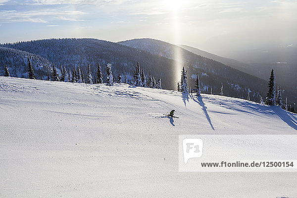 Distant Blick auf eine einsame Skifahrer auf verschneite Landschaft in Whitefish  Montana  Usa